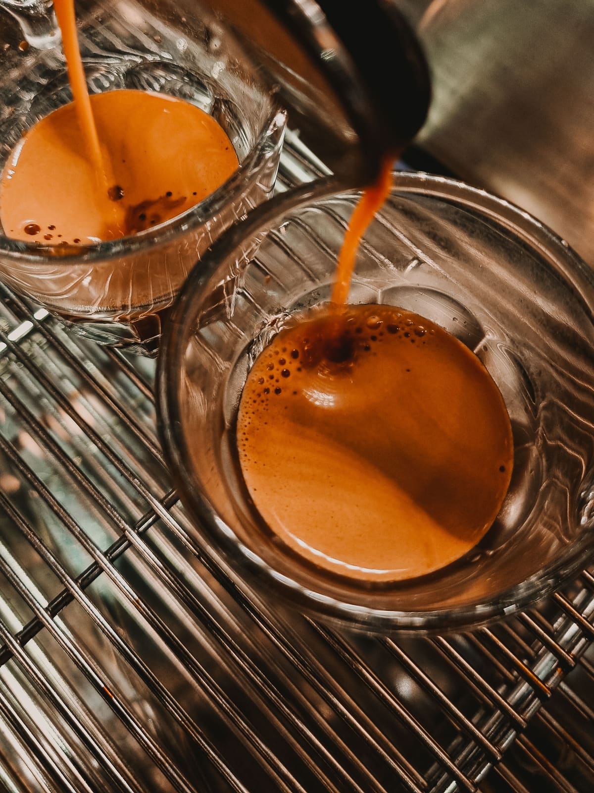 Espresso läuft aus dem Siebträger in zwei Gläser