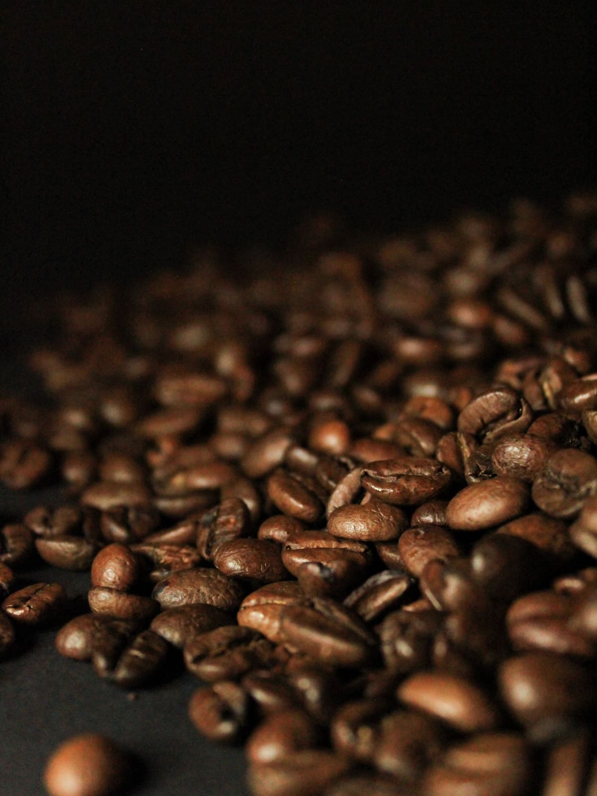 Geröstete Kaffeebohnen vor dunklem Hintergrund